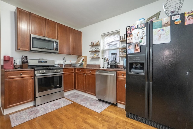 kitchen featuring appliances with stainless steel finishes and light hardwood / wood-style flooring