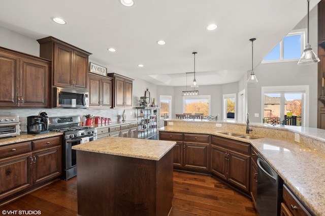 kitchen featuring a wealth of natural light, dark hardwood / wood-style floors, a kitchen island, and appliances with stainless steel finishes