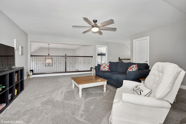 living room with carpet flooring, ceiling fan with notable chandelier, and vaulted ceiling