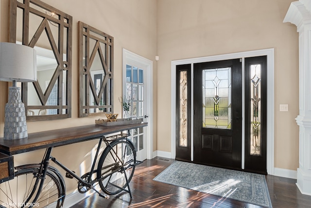 entryway with dark hardwood / wood-style flooring and decorative columns