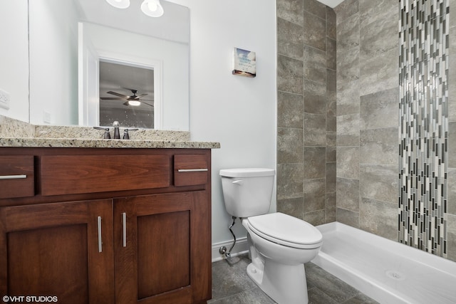 bathroom with tiled shower, toilet, tile patterned floors, vanity, and ceiling fan