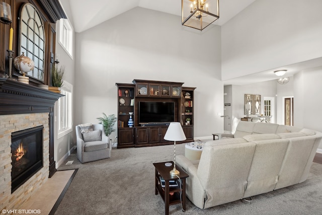 carpeted living room with a stone fireplace and high vaulted ceiling