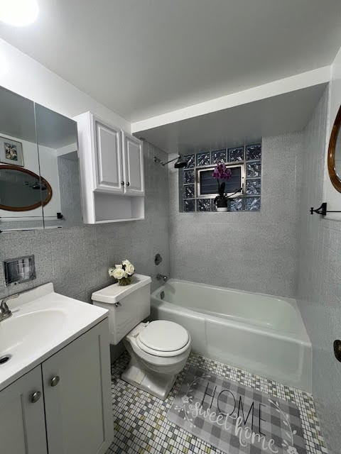 full bathroom featuring tiled shower / bath combo, tile patterned flooring, decorative backsplash, vanity, and tile walls