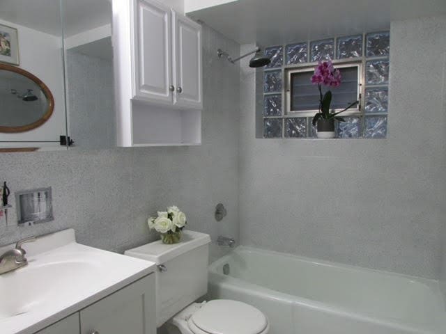 full bathroom with vanity, toilet, and tiled shower / bath combo