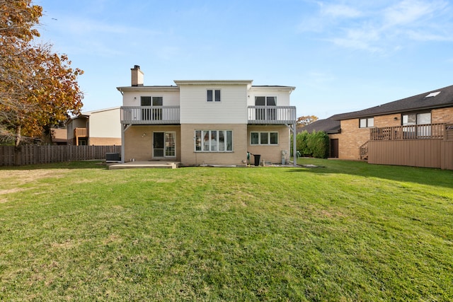 rear view of property with a patio area, central AC, a yard, and a balcony