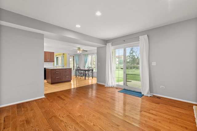 unfurnished living room featuring ceiling fan and light hardwood / wood-style flooring