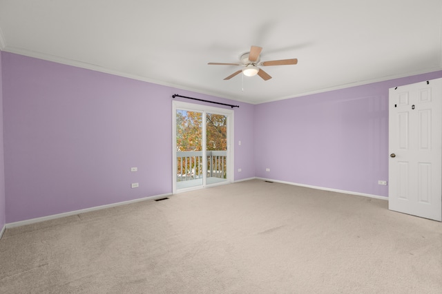 carpeted spare room featuring ceiling fan and crown molding