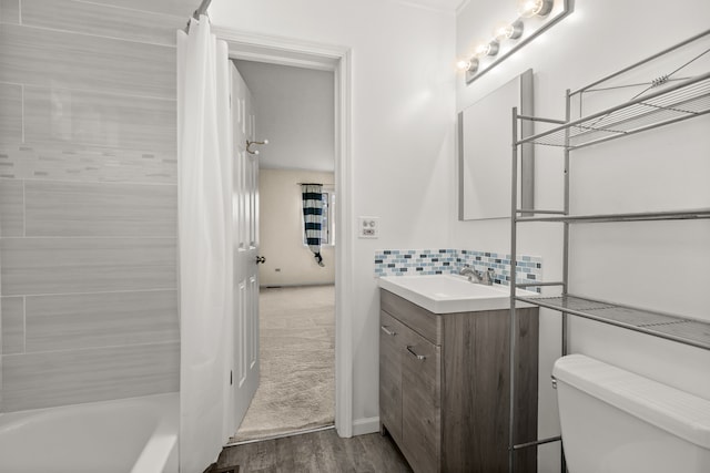 full bathroom featuring tasteful backsplash, shower / tub combo, wood-type flooring, vanity, and toilet