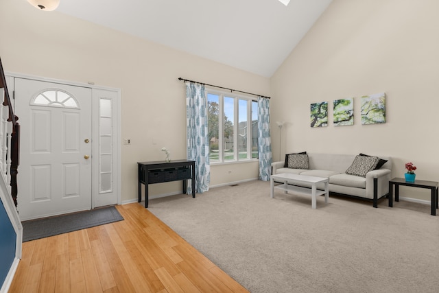 entryway with high vaulted ceiling and wood-type flooring