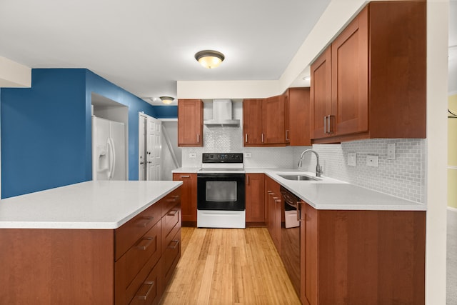 kitchen featuring decorative backsplash, sink, white appliances, wall chimney exhaust hood, and light hardwood / wood-style flooring