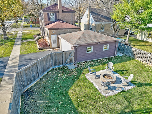 rear view of house with an outdoor fire pit, a patio, and a yard