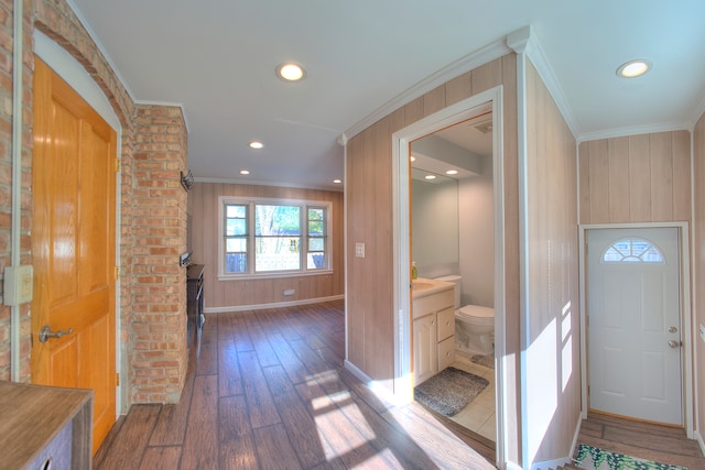 hall featuring dark hardwood / wood-style flooring, wooden walls, and crown molding