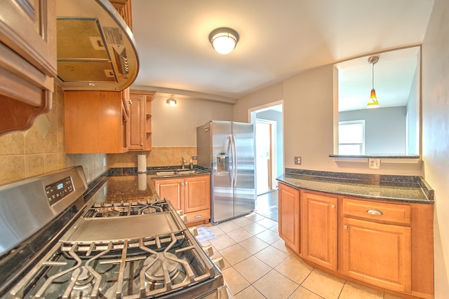 kitchen with appliances with stainless steel finishes, decorative light fixtures, light tile patterned floors, decorative backsplash, and sink