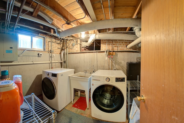 laundry room with electric panel, sink, and separate washer and dryer