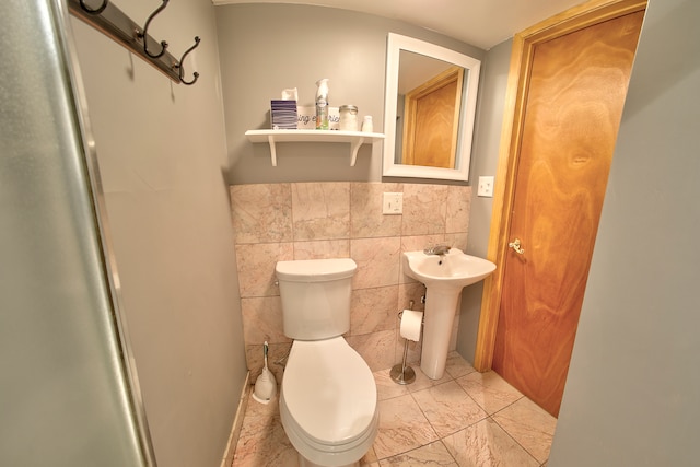 bathroom featuring tile walls, sink, and toilet