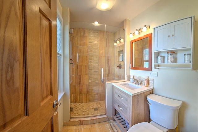 bathroom featuring tile patterned flooring, an enclosed shower, vanity, and toilet