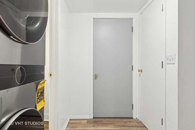 interior space featuring stacked washing maching and dryer and light hardwood / wood-style flooring