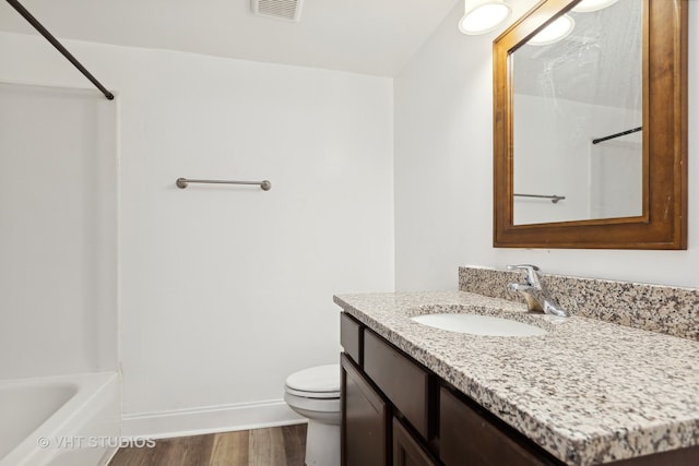 full bathroom featuring hardwood / wood-style floors, vanity, toilet, and tub / shower combination