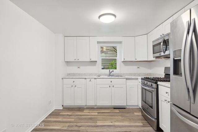 kitchen with white cabinets, appliances with stainless steel finishes, and sink