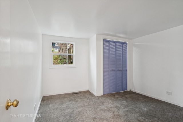 unfurnished bedroom with light colored carpet and a closet