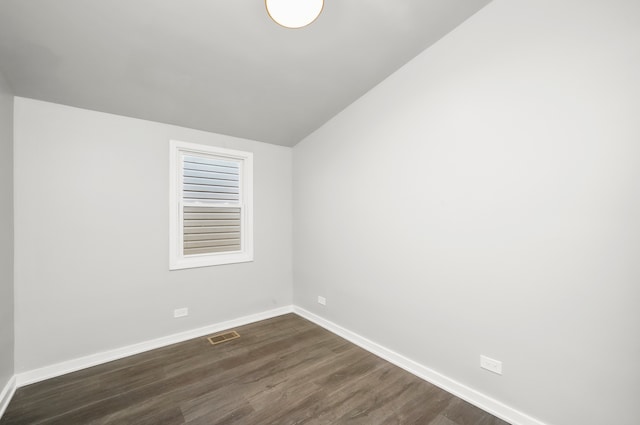 unfurnished room featuring lofted ceiling and dark hardwood / wood-style floors