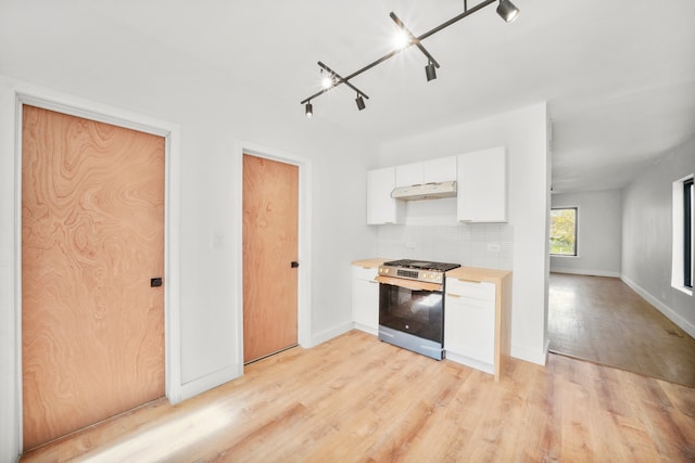 kitchen with tasteful backsplash, wooden counters, light wood-type flooring, white cabinets, and stainless steel range with gas stovetop