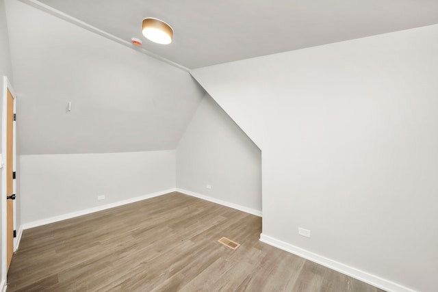 additional living space featuring hardwood / wood-style flooring and vaulted ceiling