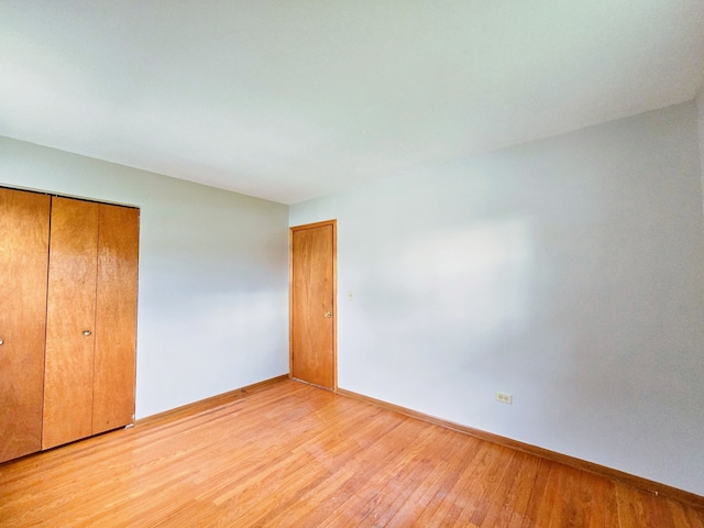 unfurnished bedroom with a closet and light wood-type flooring