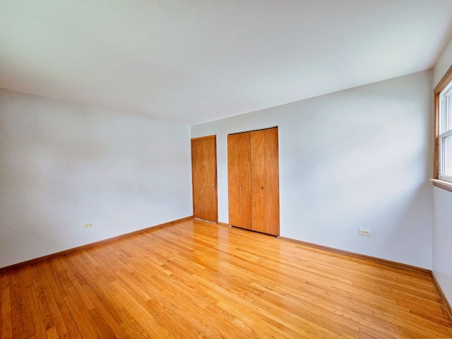 unfurnished bedroom with multiple closets and light hardwood / wood-style flooring