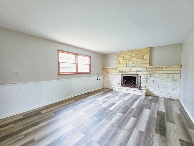 unfurnished living room with a textured ceiling, a fireplace, and hardwood / wood-style flooring