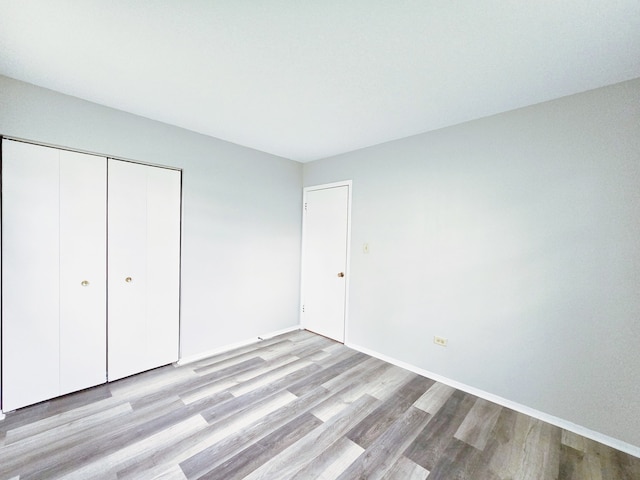 unfurnished bedroom with light hardwood / wood-style floors and a closet