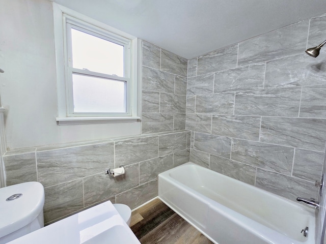 bathroom featuring wood-type flooring, toilet, and tile walls