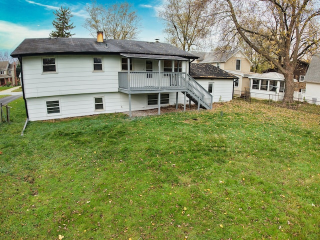 rear view of house featuring a deck and a lawn