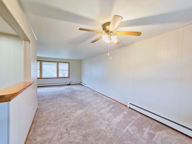 carpeted empty room with ceiling fan and a baseboard radiator