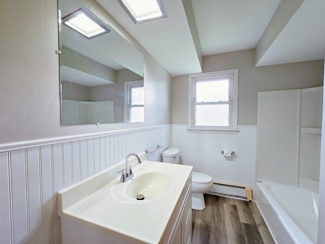 bathroom featuring wood-type flooring, vanity, a bathing tub, toilet, and baseboard heating