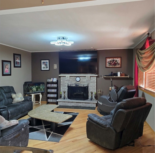 living area featuring a fireplace, wood finished floors, and crown molding