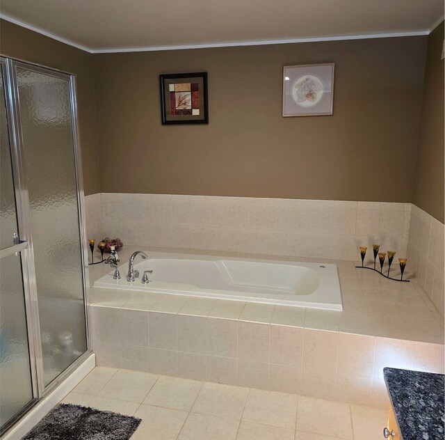 bathroom featuring tile patterned flooring and shower with separate bathtub