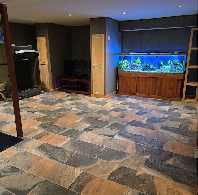 living area featuring stone finish flooring, baseboards, and recessed lighting