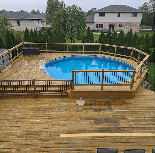 view of swimming pool with a deck and a fenced in pool