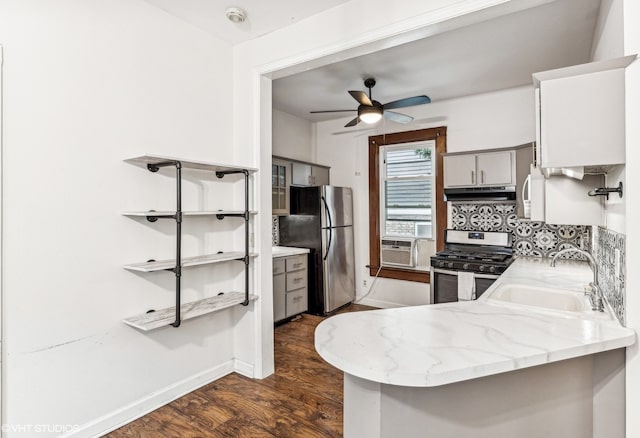 kitchen with sink, kitchen peninsula, appliances with stainless steel finishes, dark wood-type flooring, and exhaust hood