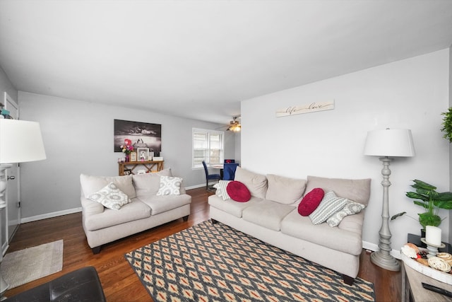 living room featuring dark wood-type flooring and ceiling fan