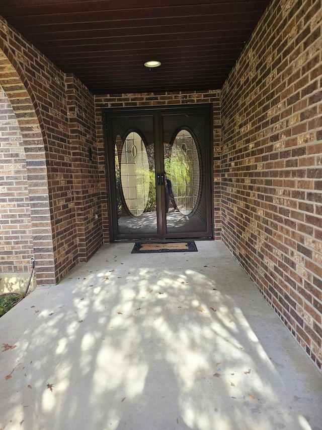 view of exterior entry with brick siding