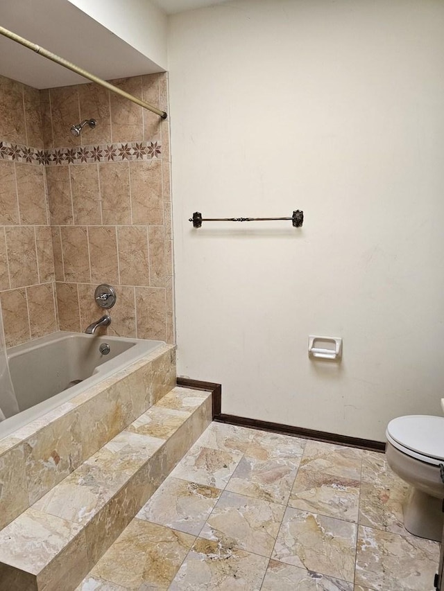 full bath with toilet, shower / bathtub combination, stone tile flooring, and baseboards