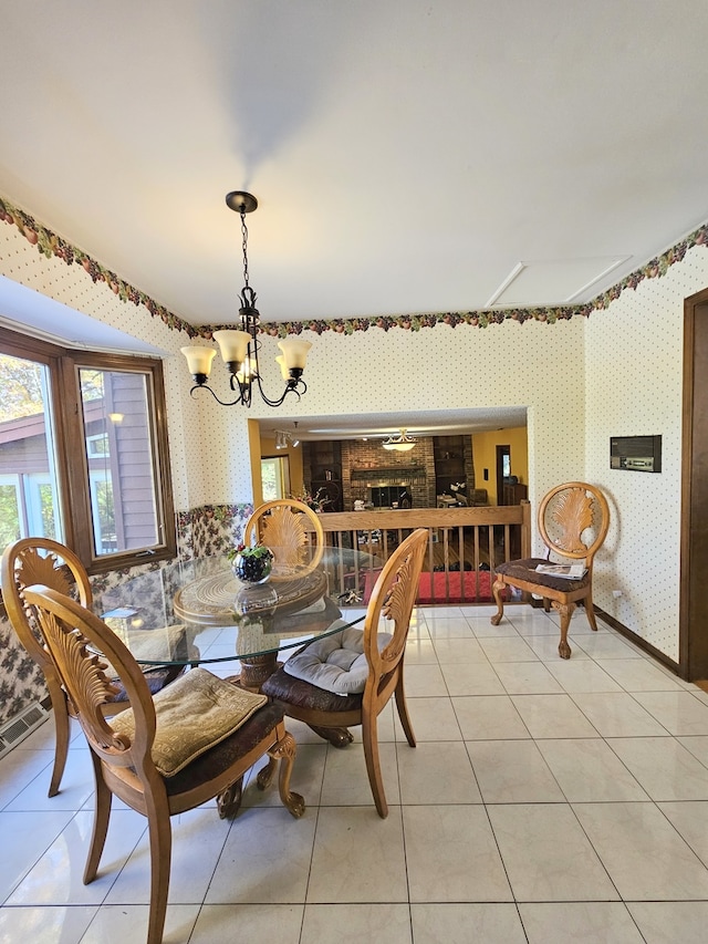 dining area featuring a notable chandelier, light tile patterned floors, visible vents, a healthy amount of sunlight, and wallpapered walls