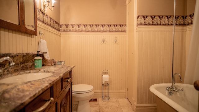 bathroom with toilet, vanity, tile patterned flooring, and a bathing tub