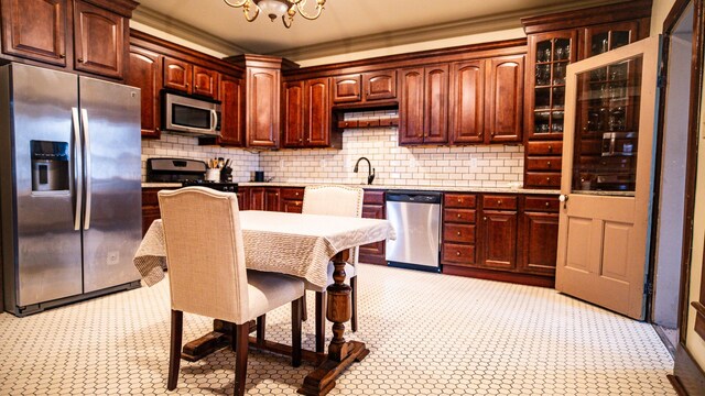 608 E Ash St, Fairbury, IL 61739 - kitchen with a sink, a notable chandelier, crown molding, light countertops, and appliances with stainless steel finishes