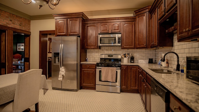 kitchen with sink, crown molding, light stone countertops, dark brown cabinets, and appliances with stainless steel finishes