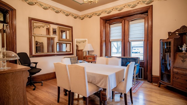 dining area featuring light hardwood / wood-style flooring and ornamental molding