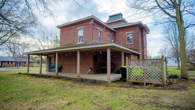 608 E Ash St, Fairbury, IL 61739 - rear view of house featuring a yard, a patio, and brick siding