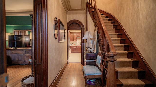 corridor with crown molding and light hardwood / wood-style flooring